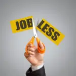 Job losses and vacant posts in AYUSH and homeopathy institutions highlighted by scissors cutting ‘Job Less’ sign